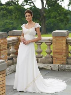 a woman in a white wedding dress posing for the camera