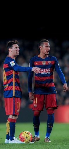 two men standing next to each other on a soccer field