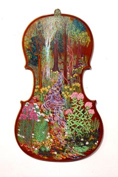 a violin with an image of a forest scene painted on it