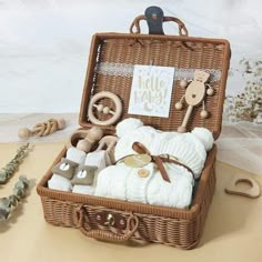 a wicker basket filled with baby items sitting on top of a table next to toys