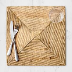 a place mat with a fork and spoon on it next to an empty glass plate