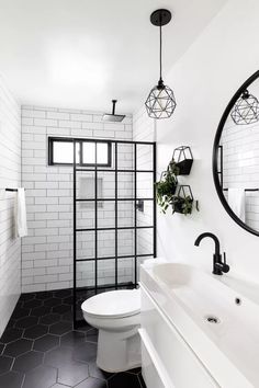 a white bathroom with black and white tiles