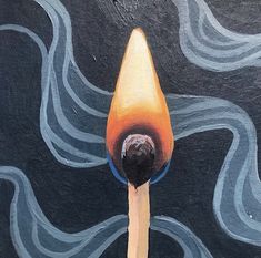 an aerial view of a person's hand holding a lit matchstick in front of a painted wall