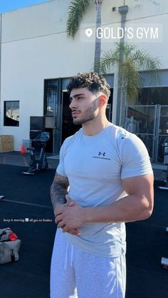 a man standing in front of a gym building with his arm wrapped around the waist