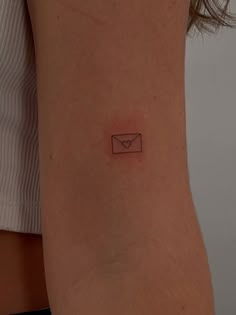 a small envelope tattoo on the back of a woman's left arm and leg