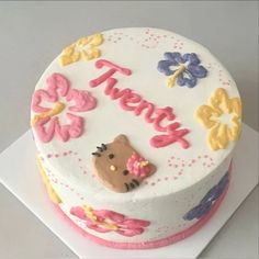 a birthday cake decorated with flowers and a cat