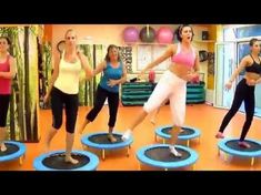 a group of women are doing exercises on trampolies in a room with exercise mats