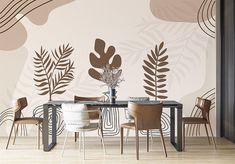 a dining room with a table and chairs in front of a wall painted with leaves