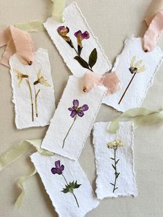 four tags with flowers and ribbons on them