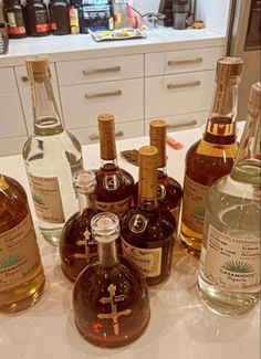 several different types of liquor are on the counter in front of some cabinets and drawers