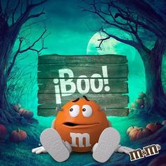 an orange monster sitting in front of a wooden sign