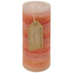 an orange and pink candle with a tag on it