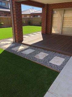 an outdoor patio with grass and stepping stones