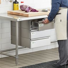 a man standing in front of a kitchen counter with an open drawer on the side