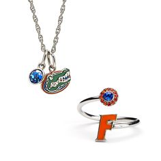 two rings with charms attached to them on a white background, one is orange and the other is blue