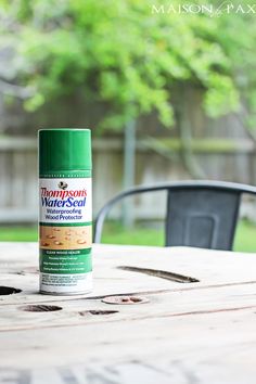 a green spray can sitting on top of a wooden table