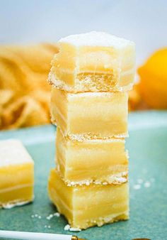 a stack of lemon bars sitting on top of a blue plate