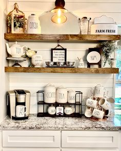 the shelves above the kitchen counter are filled with coffee cups and mugs, along with other items