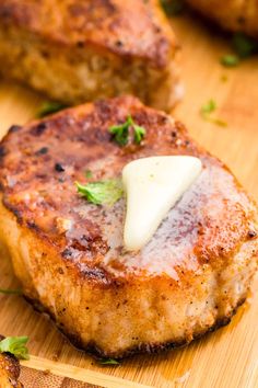 some meat with cheese on it sitting on a cutting board