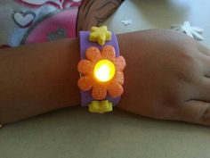 a child's hand with a light up flower bracelet