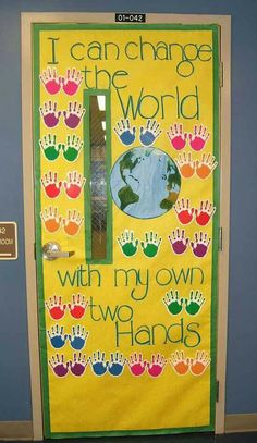 a classroom door decorated with handprints and the words i can change the world