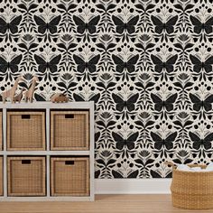 a black and white wallpaper with butterflies in the center, next to baskets on the floor