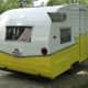 a yellow and white trailer is parked on the street