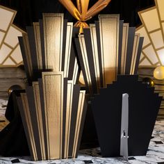 an assortment of black and gold cards on a table