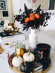 a tray with candles, pumpkins and other decorations on it in a living room