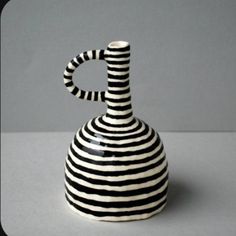 a black and white striped vase sitting on top of a table