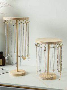 two wooden jewelry stands sitting on top of a counter