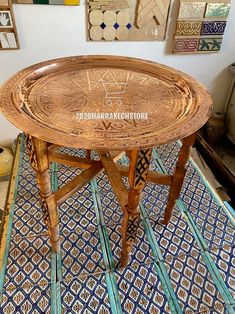 a wooden table sitting on top of a blue and white tile floor next to pictures