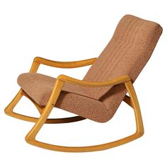 the rocking chair is made from wood and has a brown fabric seat pad on it