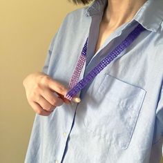 a woman wearing a blue shirt and purple lanyard