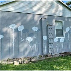 a painting on the side of a building with white flowers painted on it's walls