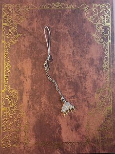 a book with a chain attached to it and a small elephant charm hanging from the front