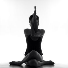 a woman is sitting on the floor doing yoga