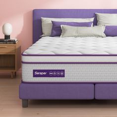 a purple bed frame with two pillows on it and a night stand next to it