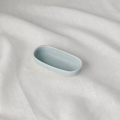 an empty bowl sitting on top of a white sheet