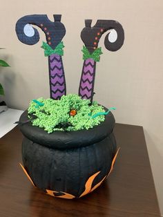 a decorated halloween planter sitting on top of a wooden table