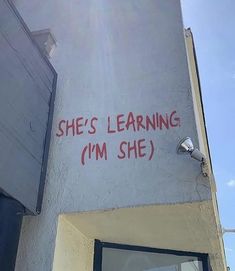 graffiti on the side of a building that says she's learning i'm she