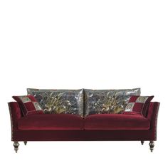 a red velvet couch with two pillows on it's back and the arms folded down