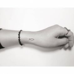 a black and white photo of a person's arm with a cross tattoo on it