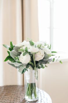 a vase filled with white flowers on top of a table