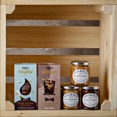 honey and chocolate products are on display in a wooden crate