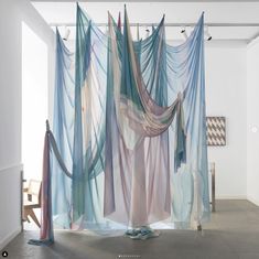 an art installation with sheer curtains hanging from the ceiling