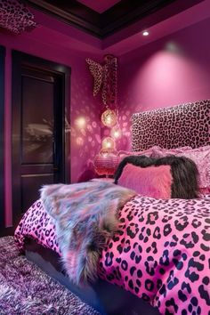 a bedroom decorated in pink and black with leopard print on the bed, fur rugs and pillows