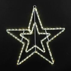 a lighted star ornament on a black background