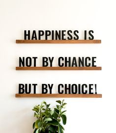 two wooden shelves with words on them that say happiness is not by chance but by choice