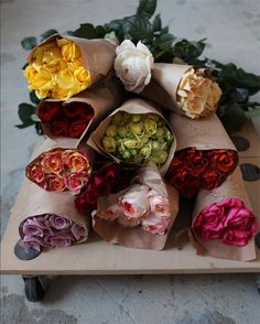 a bunch of flowers that are sitting on a counter top with paper wrapped around them